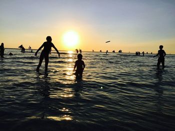 Silhouette of people at beach during sunset