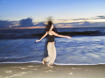 Woman dancing on sand at beach