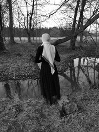 Rear view of woman standing on field