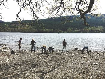 Children standing by river against sky