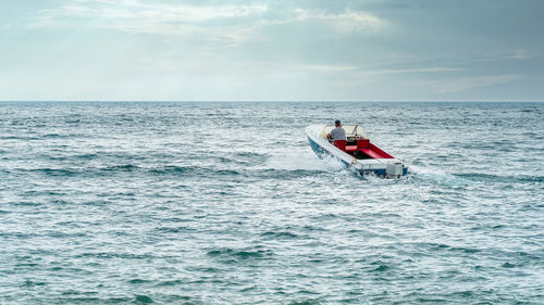 Forward - beyond the horizon in motorboat on sea against sky