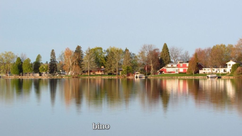 water, reflection, lake, tree, plant, sky, nature, no people, architecture, built structure, clear sky, tranquility, day, beauty in nature, building, reservoir, house, scenics - nature, building exterior, tranquil scene, outdoors, body of water, copy space, waterfront