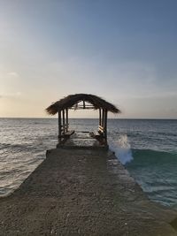 Lifeguard hut on beach against sky