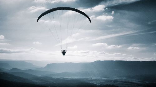 Person paragliding against sky