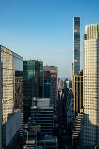 Modern buildings in city against clear blue sky