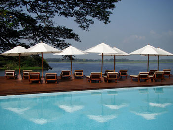 Swimming pool by sea against sky