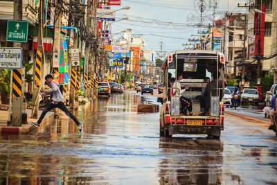 People walking on city street during rainy season