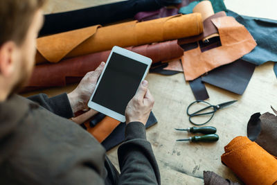 High angle view of man using mobile phone on table