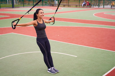 Full length of woman playing with umbrella