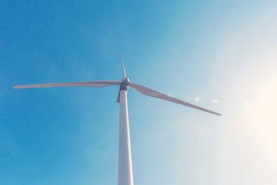 Low angle view of windmill against blue sky