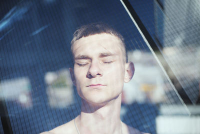 Portrait of teenage boy seen through window