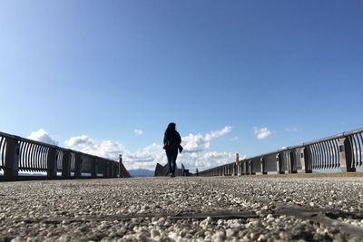Man standing on train against clear blue sky