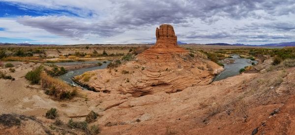 Rock formations on landscape against cloudy sky