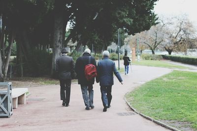 Rear view of family walking on footpath