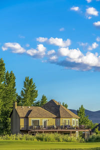 Houses by trees and buildings against sky