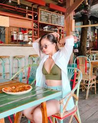 Young woman sitting on table at restaurant