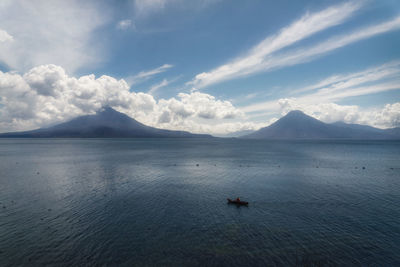 Scenic view of sea and mountains against sky