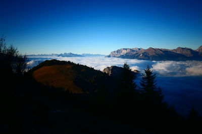 Scenic view of snowcapped mountains against blue sky