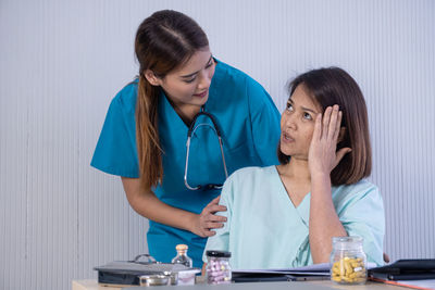 Woman looking at camera while sitting on table