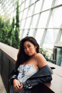 Portrait of young woman against window