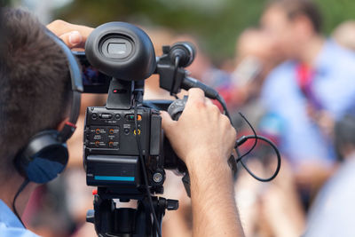 Rear view of man operating camera during event