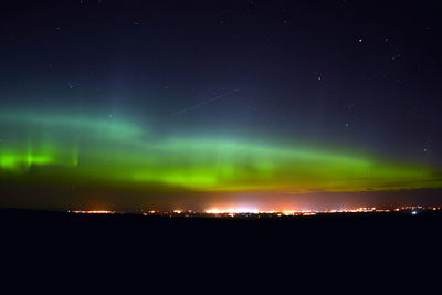 Scenic view of illuminated landscape against sky at night