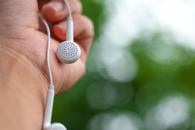 Close-up of person hand holding headphones