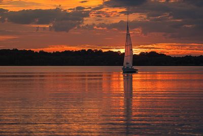 Silhouette sailboat on sea against sky during sunset