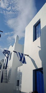 Low angle view of flags on building against sky