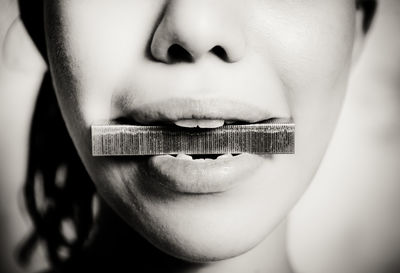 Cropped image of woman with iron bar in mouth