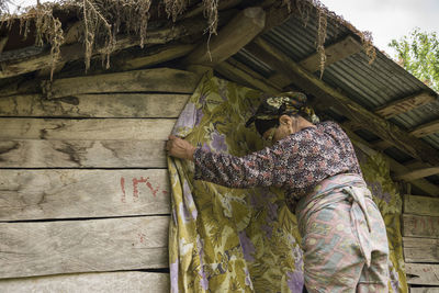 Rear view of woman standing against building