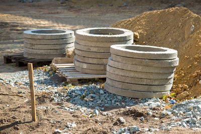 Reinforced concrete rings lie on pallets at the construction site.