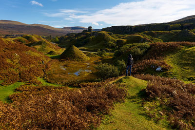 Tourist climbing down a mountain at fairy glen on isle of skye in scotland