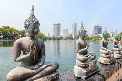 Budda statues in the center of colombo, in the background skyscrapers.