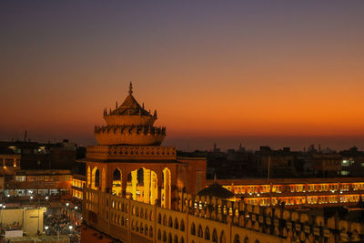Illuminated buildings against sky during sunset