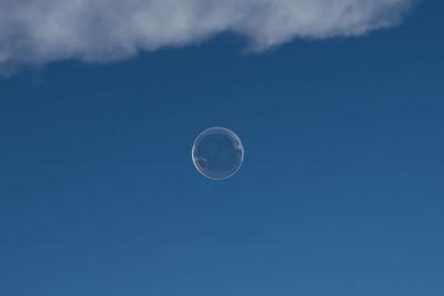 Low angle view of moon against blue sky