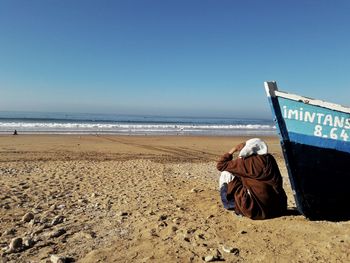 Man on beach against clear sky