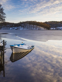 The morning sun reflects off the calm lake, framed by a jetty.