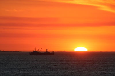 Scenic view of sea against orange sky