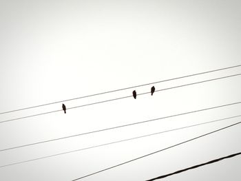 Low angle view of electricity pylon against clear sky