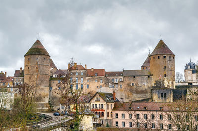 Old buildings in city against sky