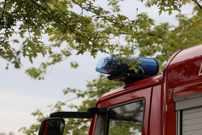 Fire engine by trees against sky