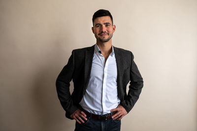 Young man standing against gray background