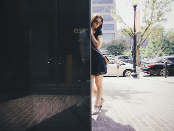 Young woman standing on street in city