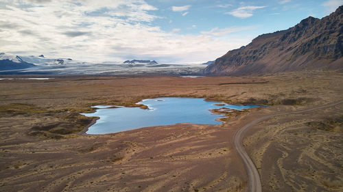 Scenic view of land and mountains against sky