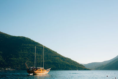 Sailboats sailing in sea against clear sky