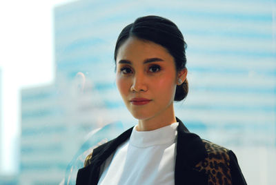 Portrait of young woman against blurred background