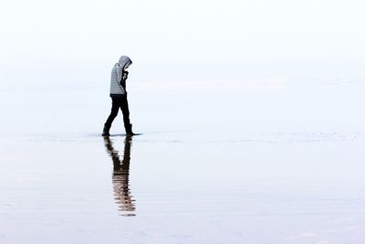 Man standing on beach against sky