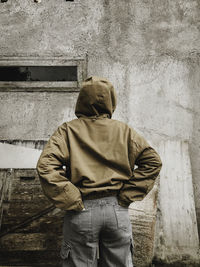 Rear view of man standing against wall