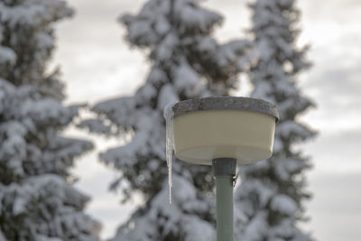 Low angle view of electric lamp against sky